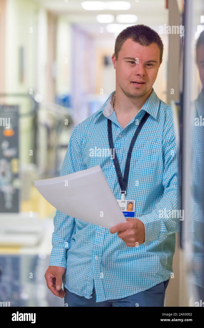 Man with Down Syndrome doing paperwork for a hospital Stock Photo