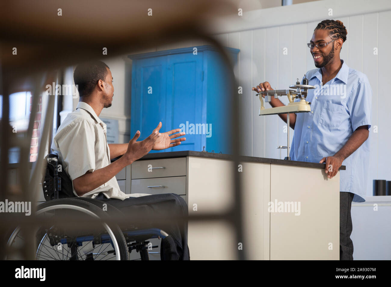 Two students who had Spinal Meningitis working in a science lab, measuring mass with a precision scale Stock Photo