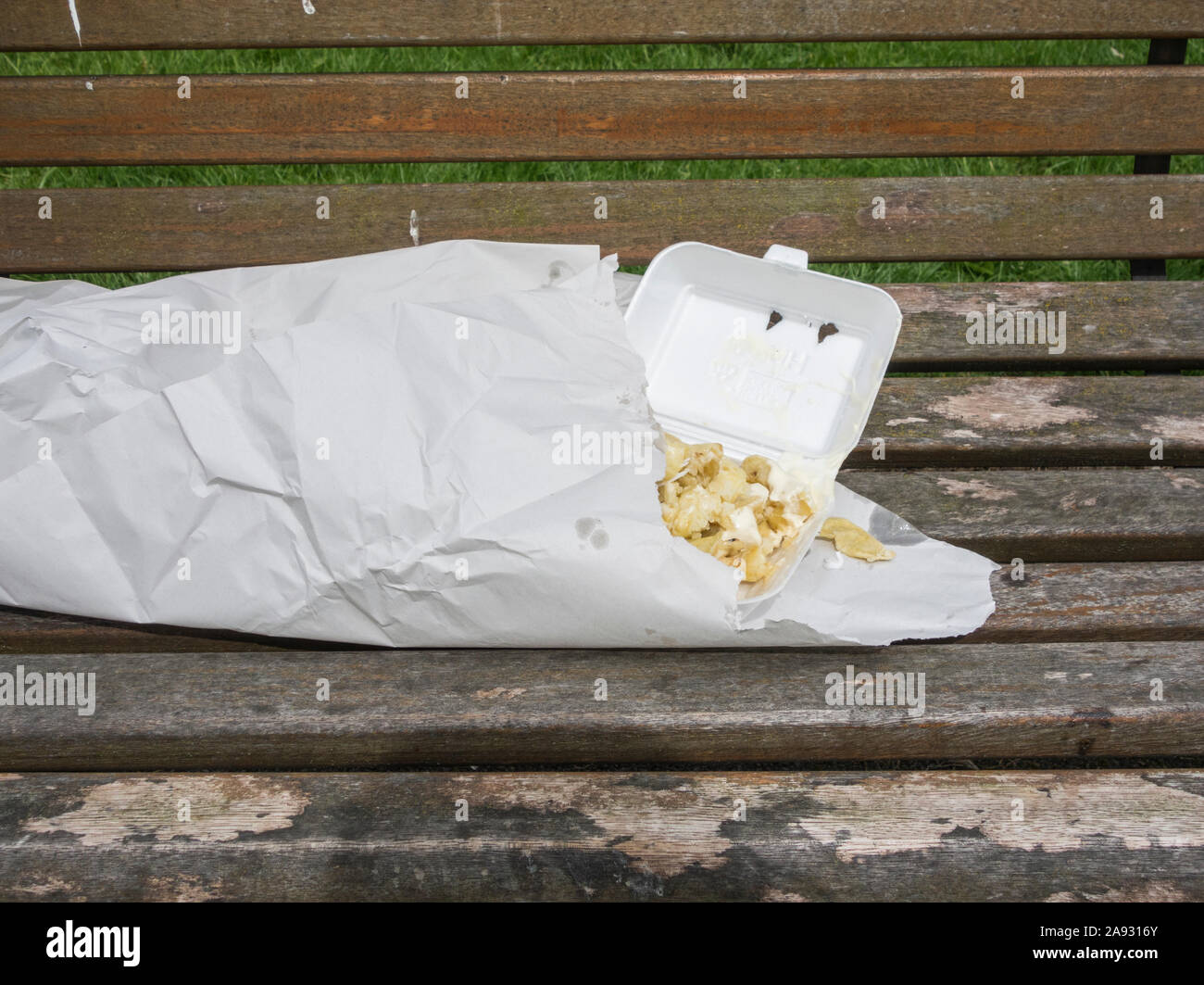 Discarded fish and chips on park bench. UK Stock Photo