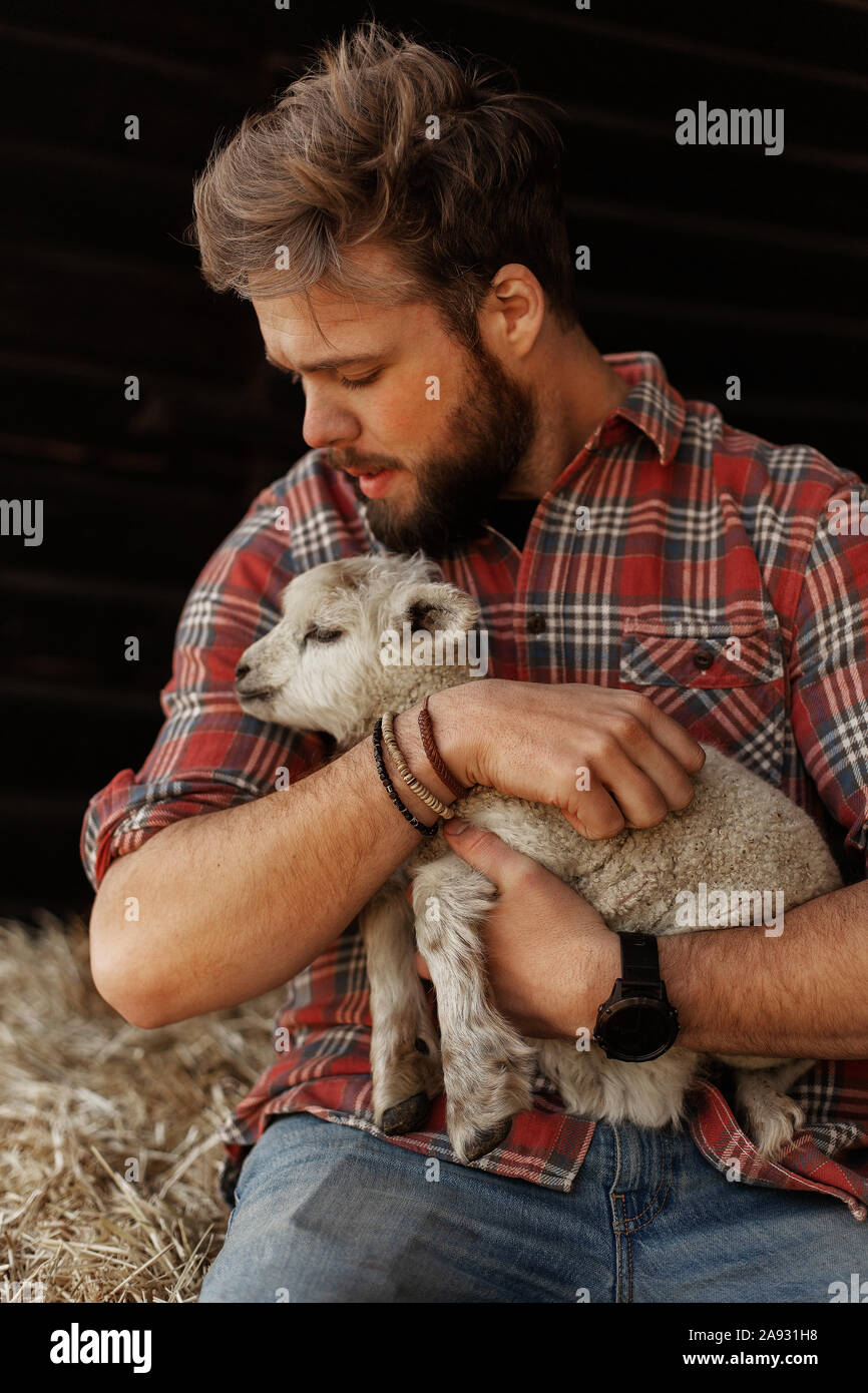 Farmer holding lamb Stock Photo Alamy