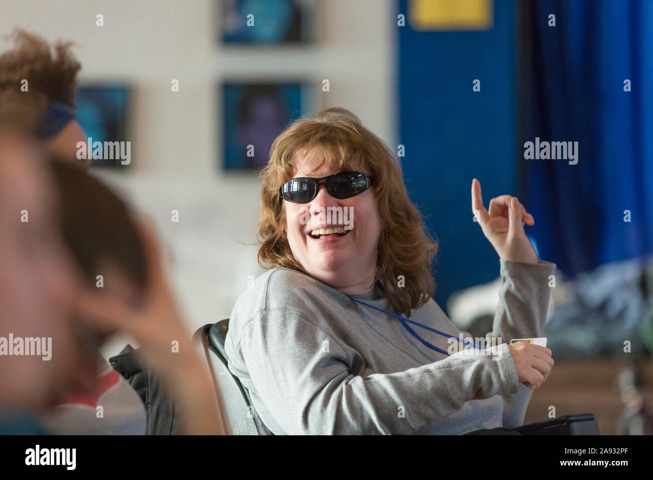 Woman with Cerebral Palsy and Visual impairment talking with other people in a meeting Stock Photo