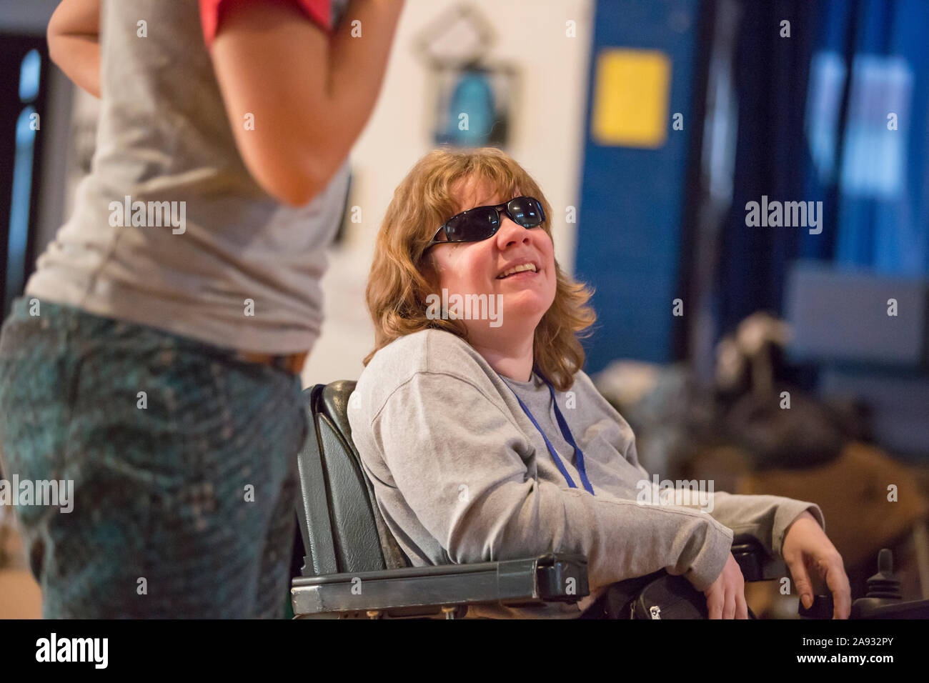 Woman with Cerebral Palsy and Visual impairment talking with other people in a meeting Stock Photo