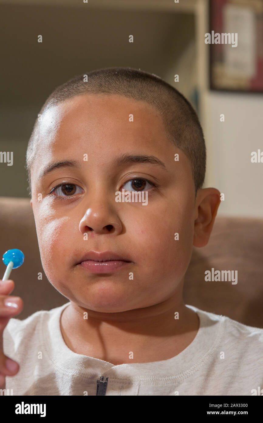 Portrait of Hispanic boy with Autism eating a lollypop Stock Photo