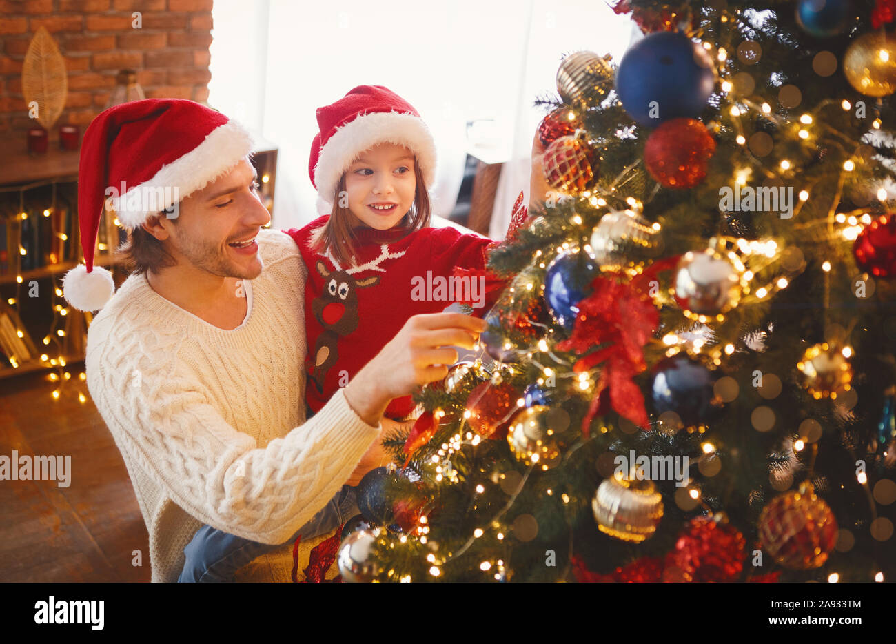 Little girl enjoying Christmas tree with her father Stock Photo - Alamy