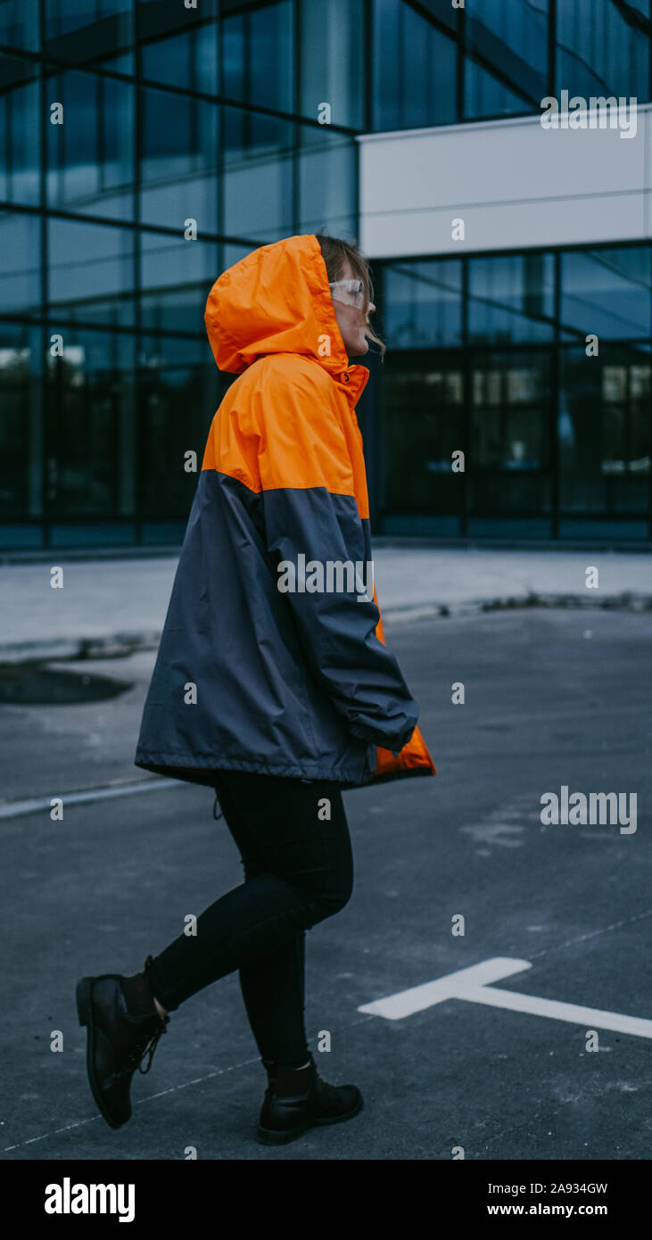 Girl in orange protective overalls and glasses. Air pollution and hazard concept Stock Photo