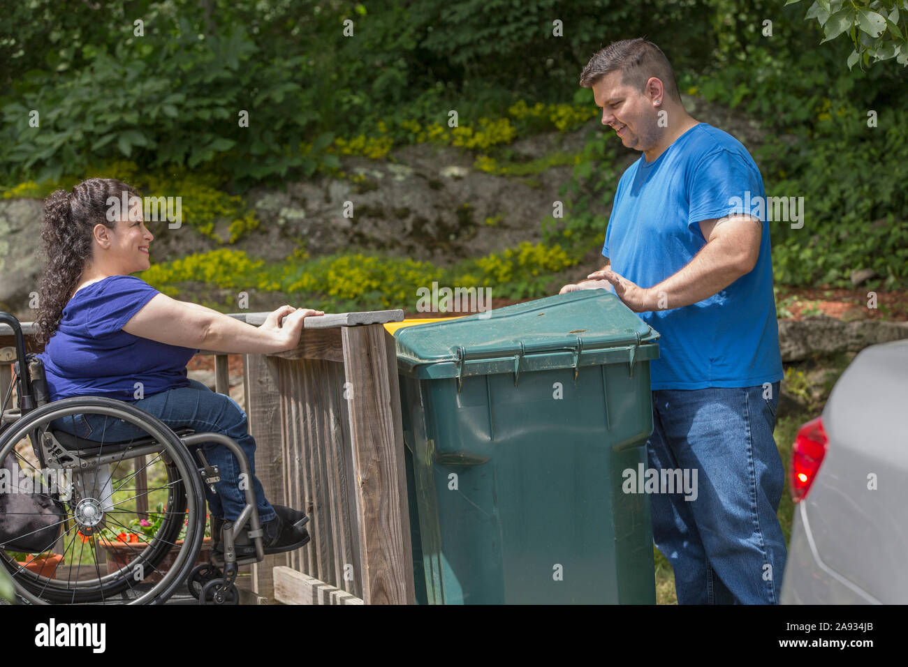 Woman with Spina Bifida and her husband taking out the garbage Stock Photo