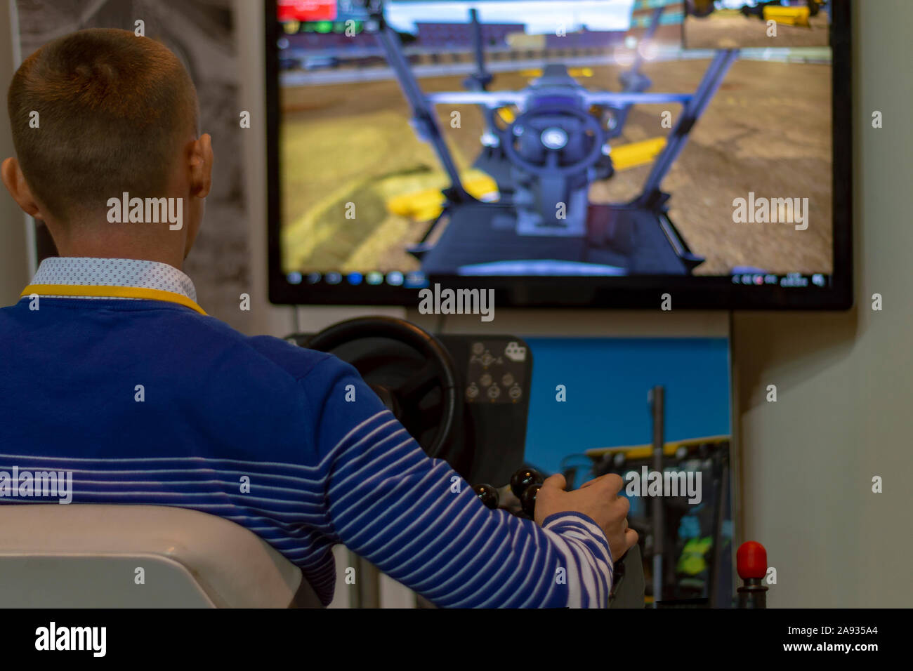 A man controls a tractor simulator an excavator, rear view. Surgut