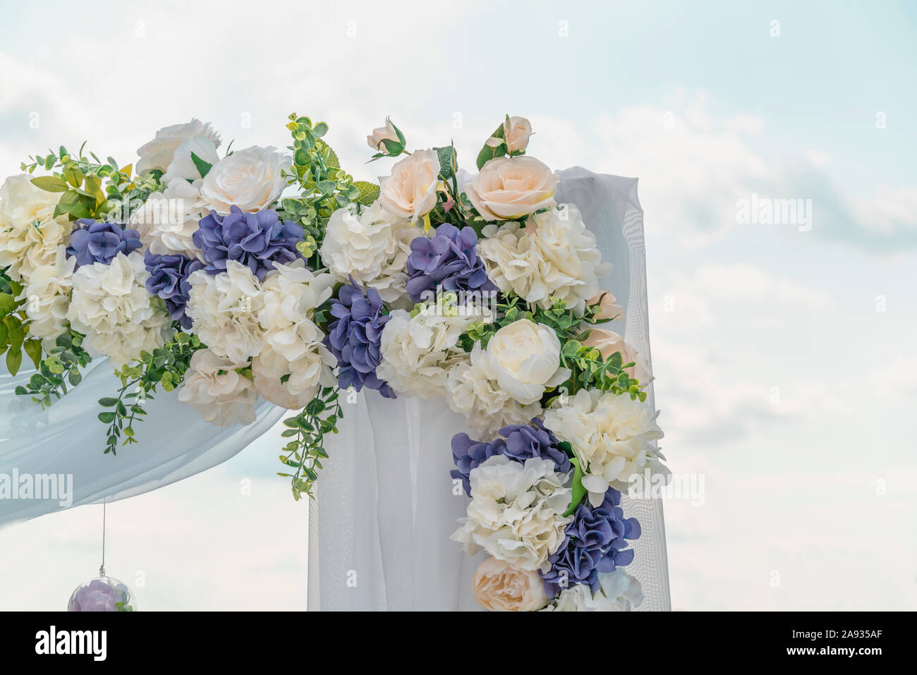 Wedding arch for the ceremony outdoors, fragment, close up. Symbol of eternal love between man and woman. Background is blu sky. Horizontal image. Stock Photo