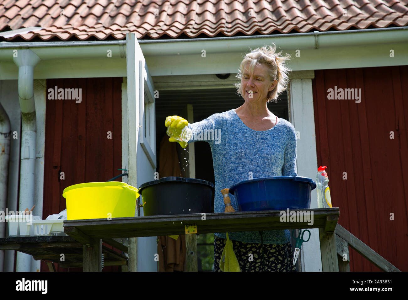 Woman washing dishes in garden Stock Photo