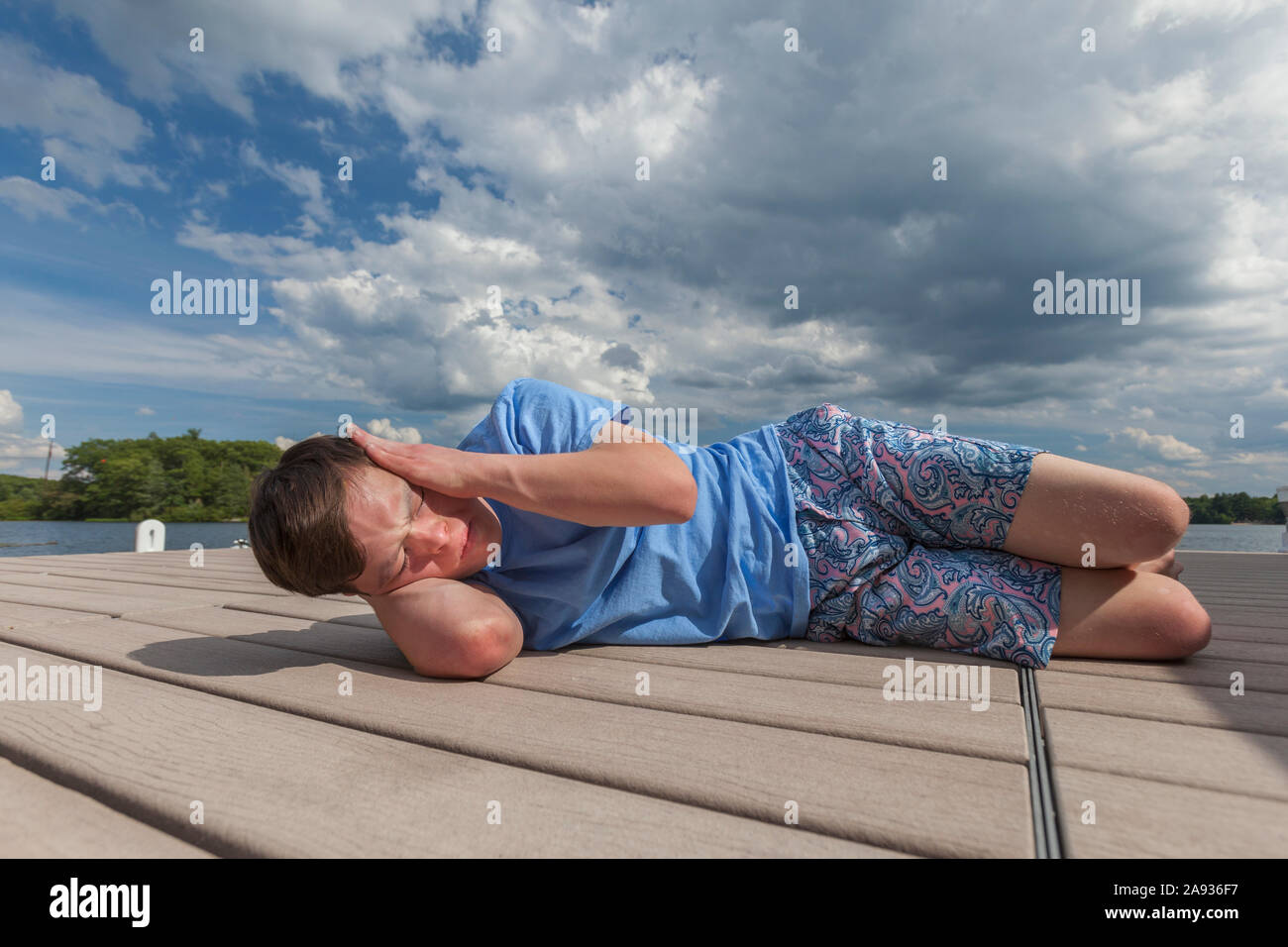 Young man with Down Syndrome playing on a dock Stock Photo