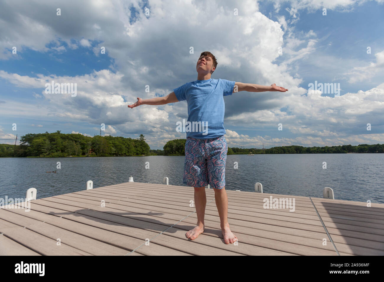 Young man with Down Syndrome standing on a dock Stock Photo