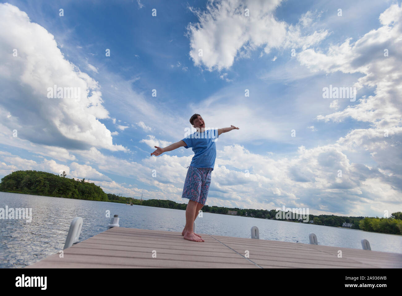 Young man with Down Syndrome playing on a dock Stock Photo