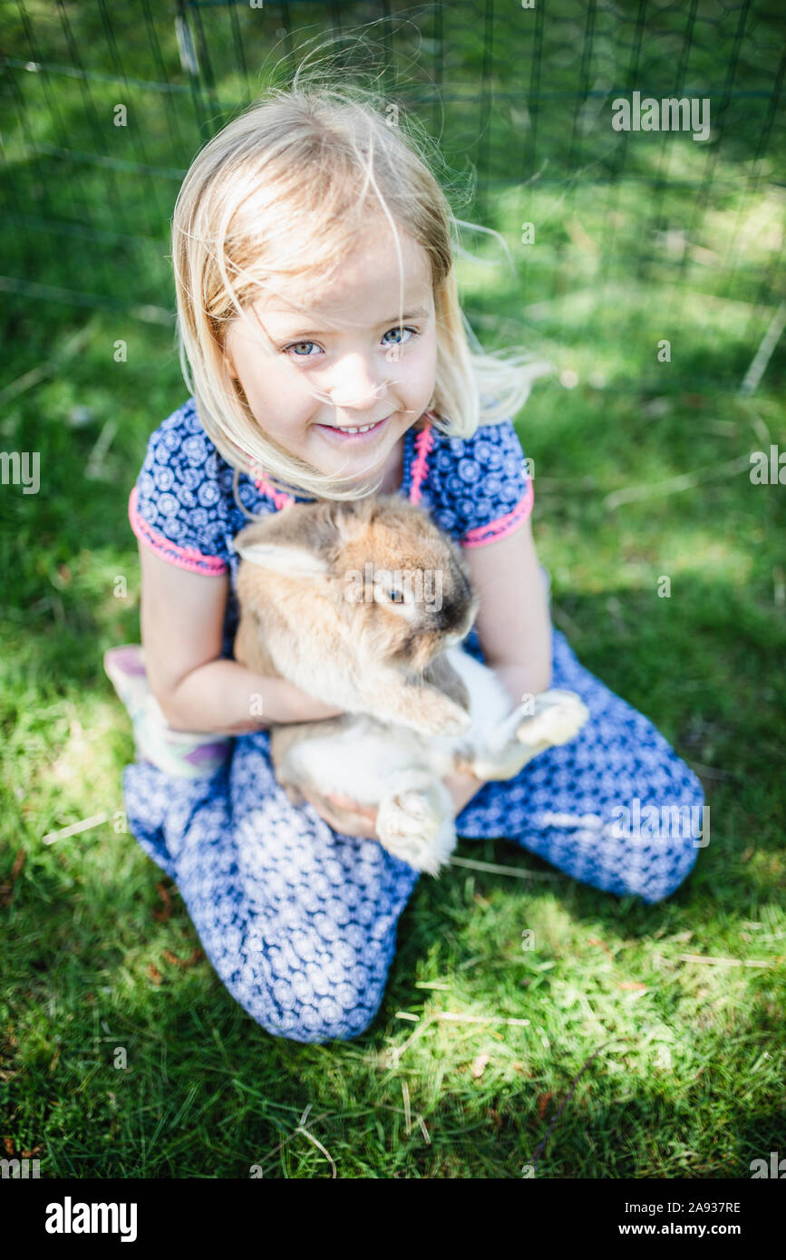 Girl holding rabbit Stock Photo - Alamy