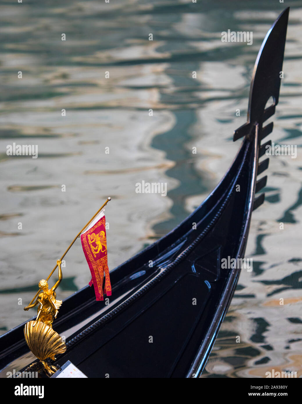Close-up detail of a golden sculpture decoration holding the Venetian flag on a Gondola in Venice, Italy. Stock Photo