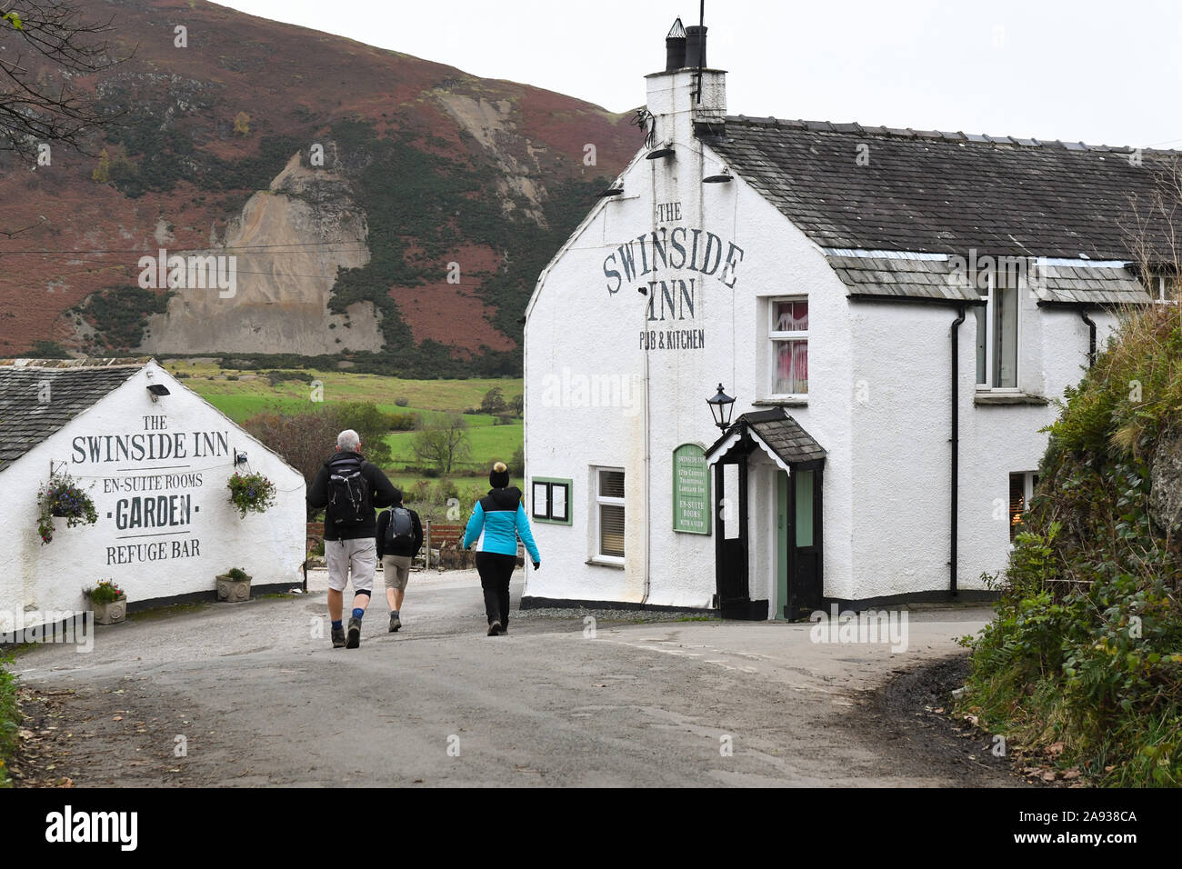 walkers in the Lake District walking to the Swinside Inn Keswick Stock Photo