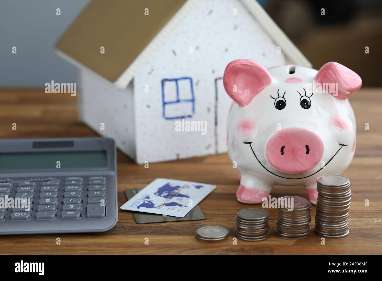 Calculator with piggy bank against home background Stock Photo - Alamy