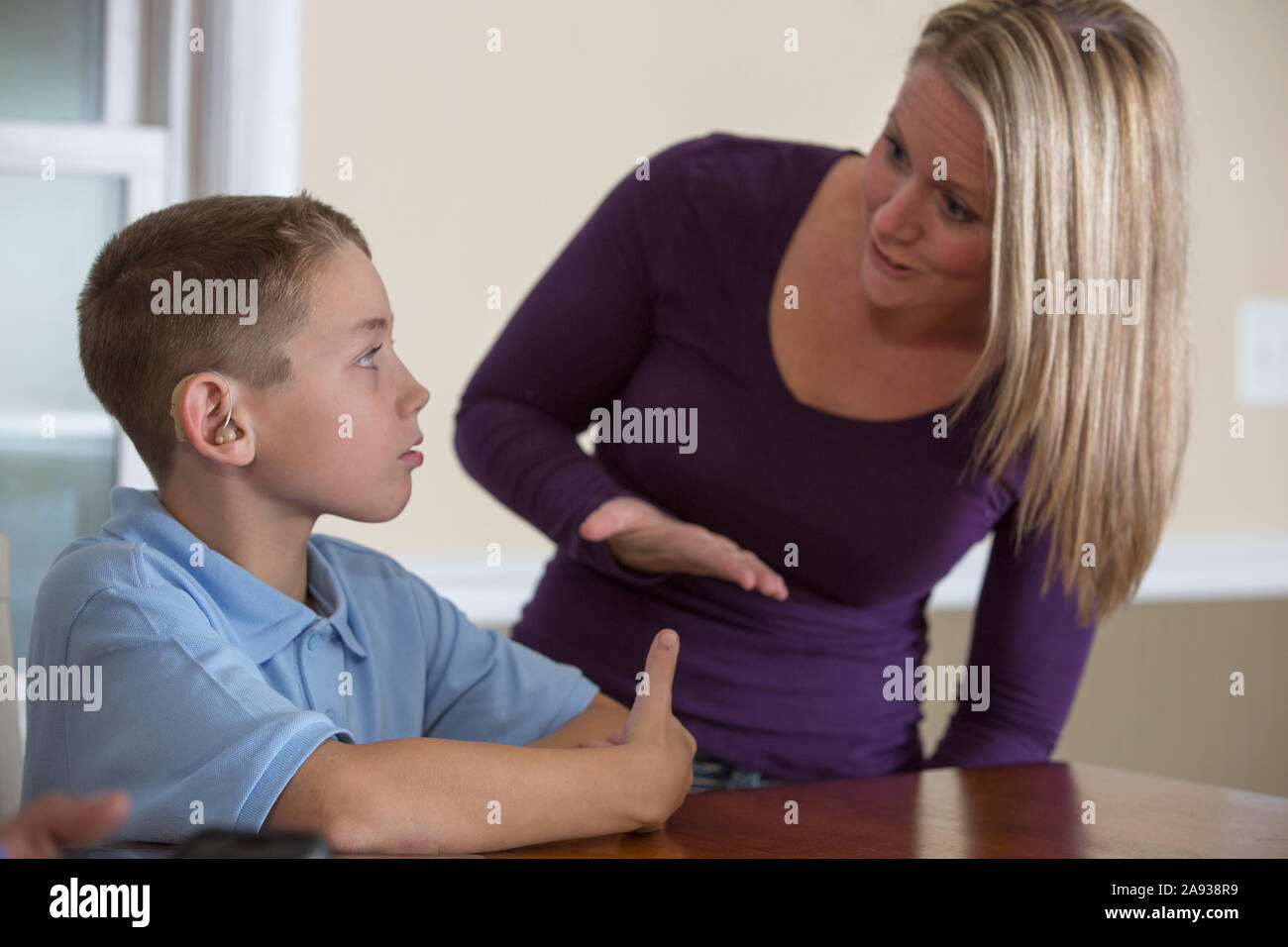 Mother and son communicating in American Sign Language about 'Good' at home Stock Photo