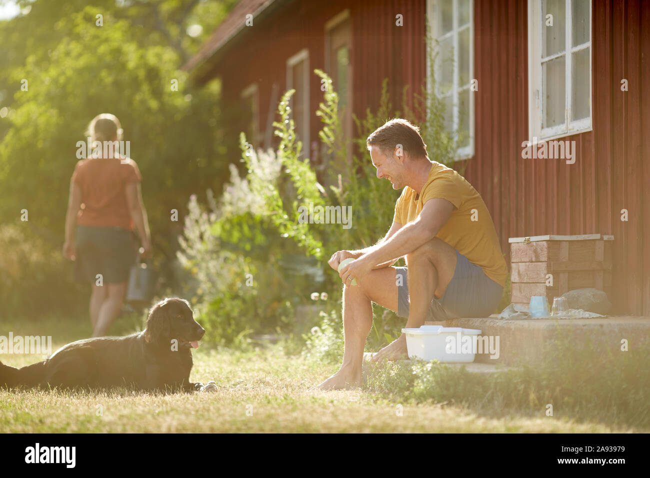 Man with dog in front of house Stock Photo