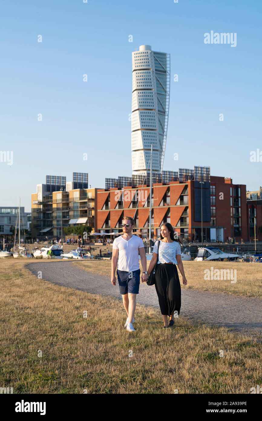 Couple walking, Turning Torso on background, Malmo, Sweden Stock Photo