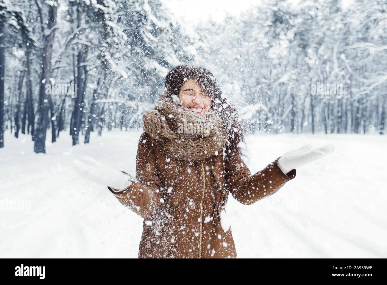 Excited Girl Throwing Snow Having Fun Walking In Winter Forest Stock Photo