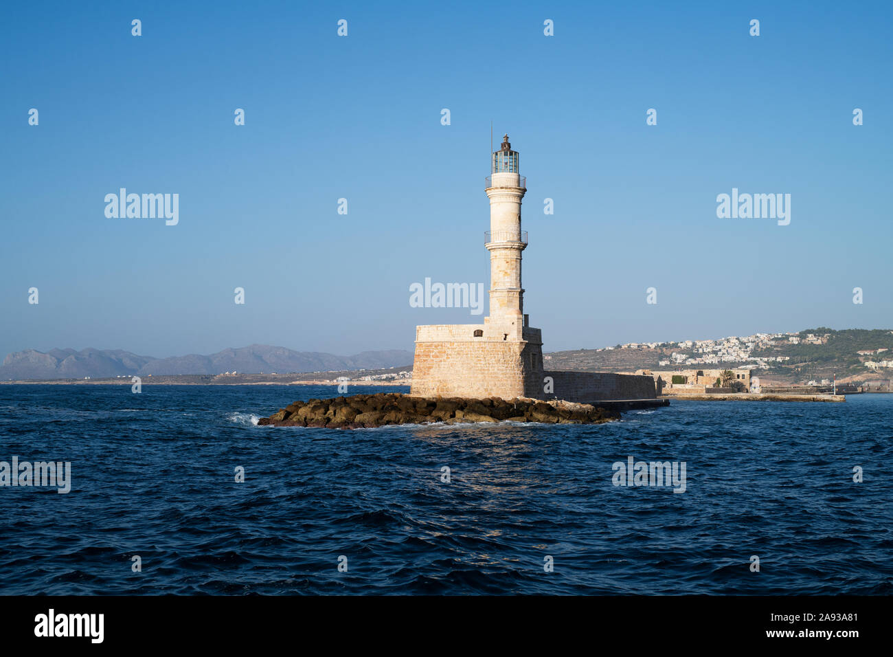 View of lighthouse on rocky island Stock Photo