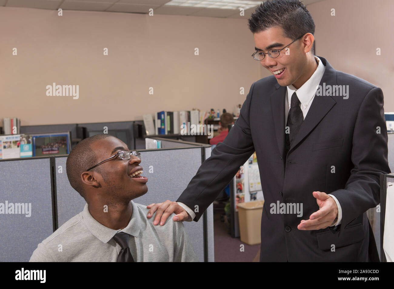 Two men with Autism talking and smiling in an office Stock Photo