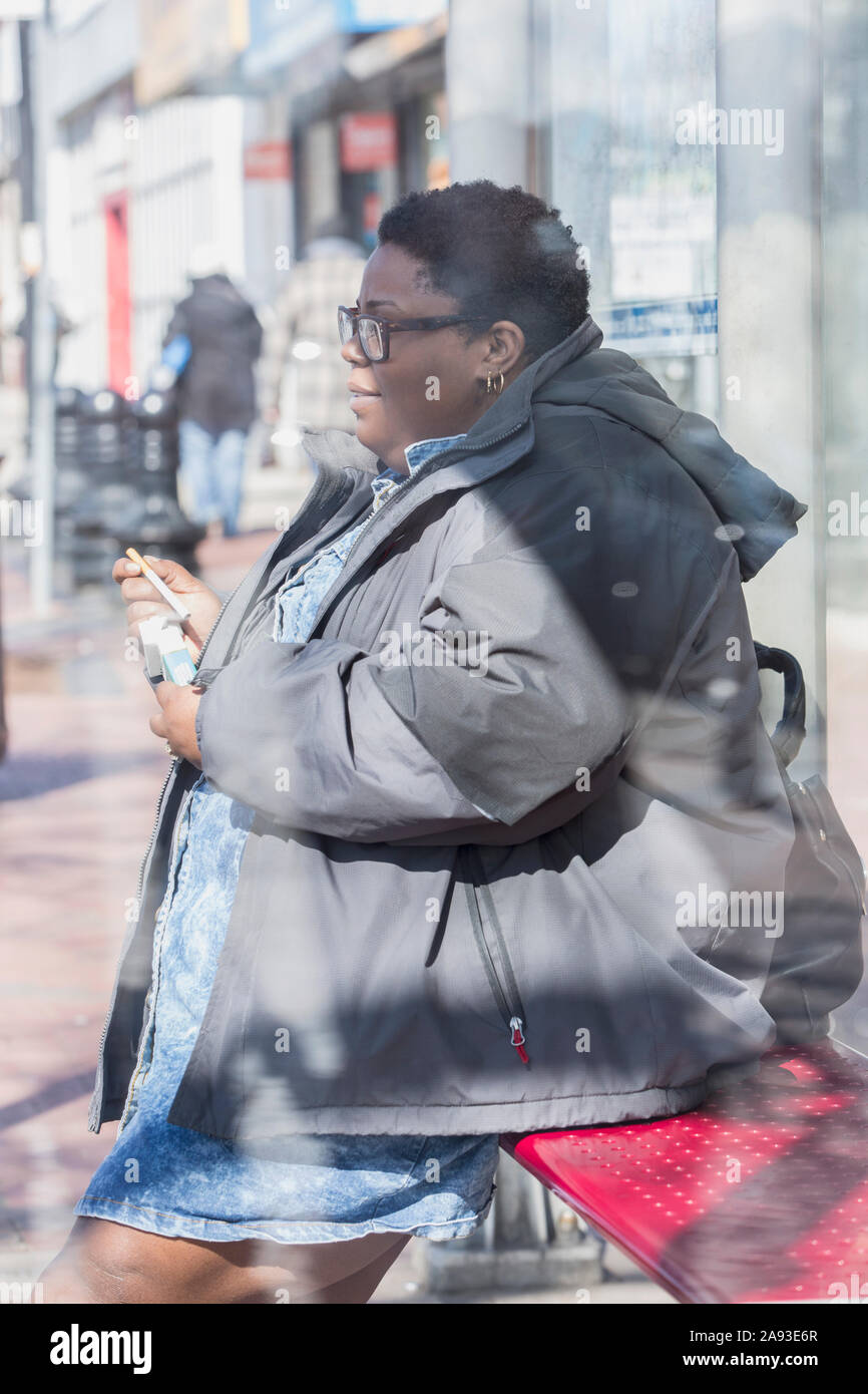 Woman with bipolar disorder relaxing in her neighborhood and taking out a  cigarette Stock Photo
