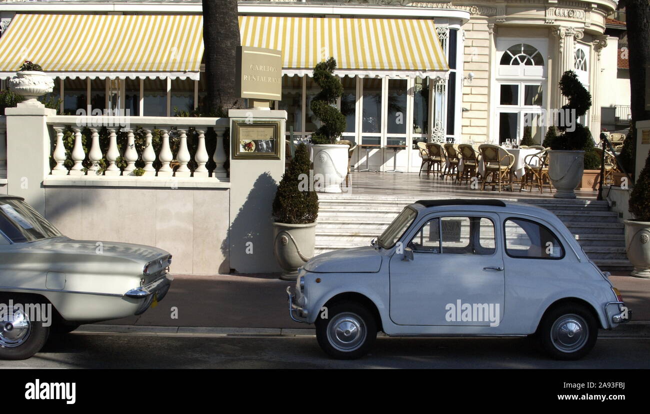 A BUICK SPECIAL DELUXE AND A FIAT 500 PARKED ON THE FRONT OF THE CARLTON HOTEL IN CANNES LA  CROISETTE - FRANCE VINTAGE - VINTAGE CARS - COLOR IMAGE ARCHIVE © Frédéric BEAUMONT Stock Photo