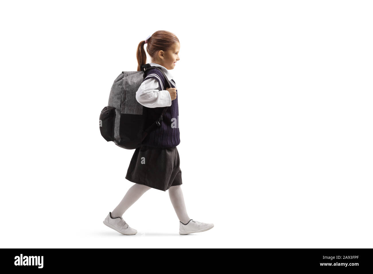 Full length profile shot of a schoolgirl going to school isolated on white background Stock Photo