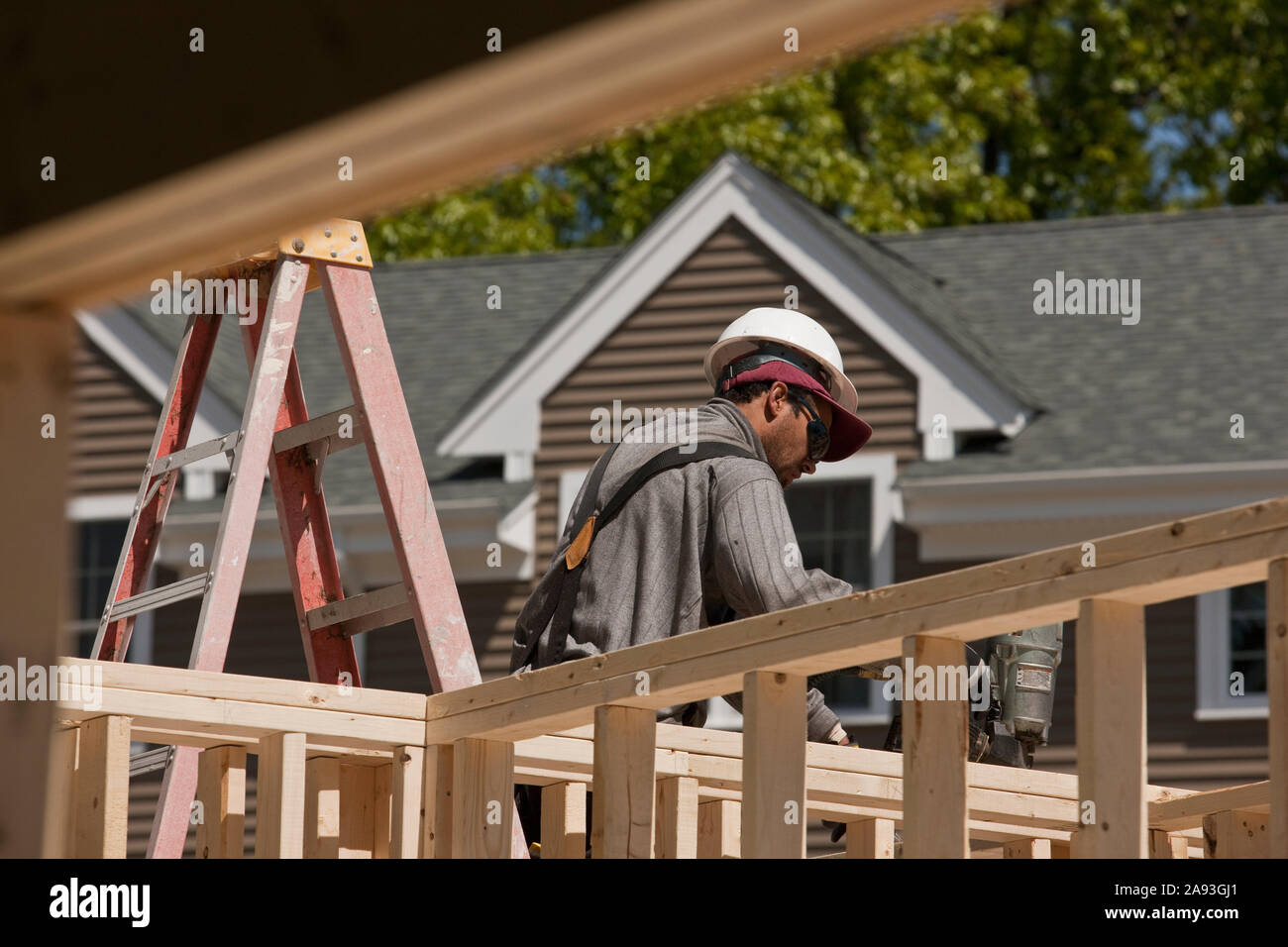 Carpenter using nail gun on framing Stock Photo Alamy