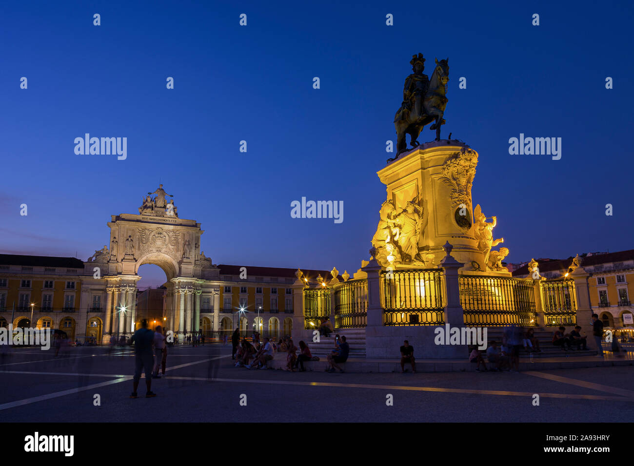 The 18th century Arco da Rua Augusta (triumphal arch gateway), tourists and statue of King Jose I at the Praca do Comercio square in Lisbon at dusk. Stock Photo