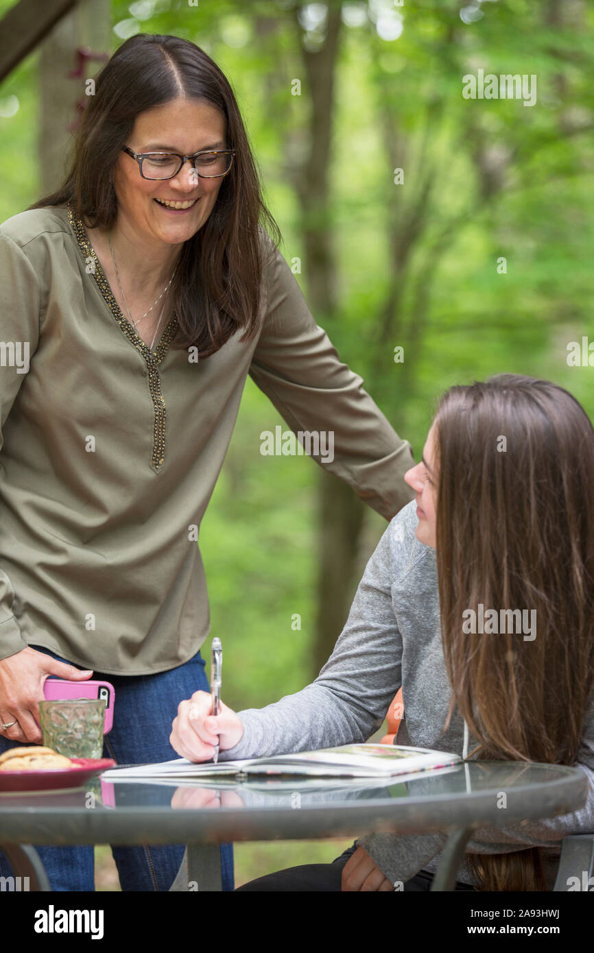 Woman with Multiple Sclerosis helping her daughter do homework Stock Photo
