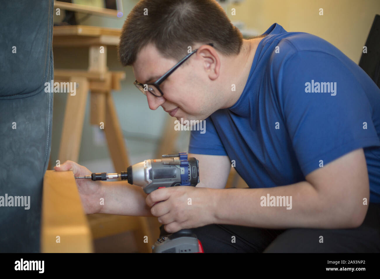 Man with Visual Impairment using a drill Stock Photo