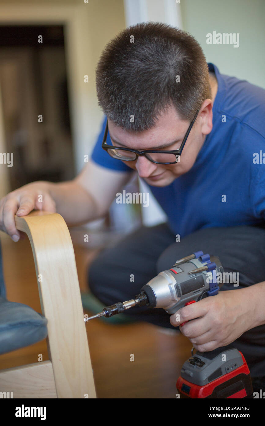 Man with Visual Impairment using a drill Stock Photo