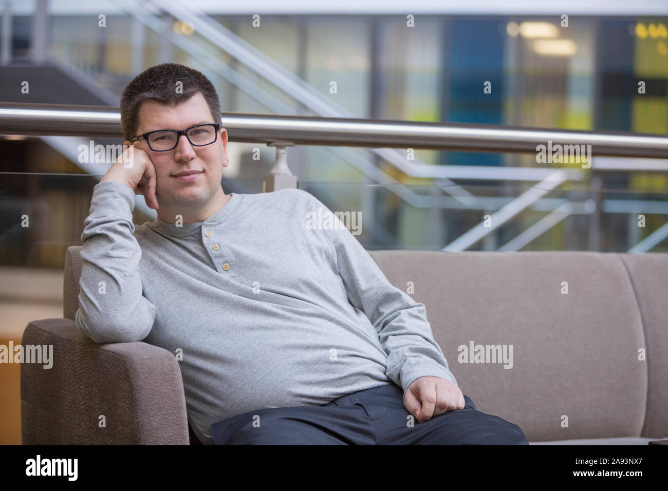 Man with Visual Impairment sitting on sofa at school Stock Photo