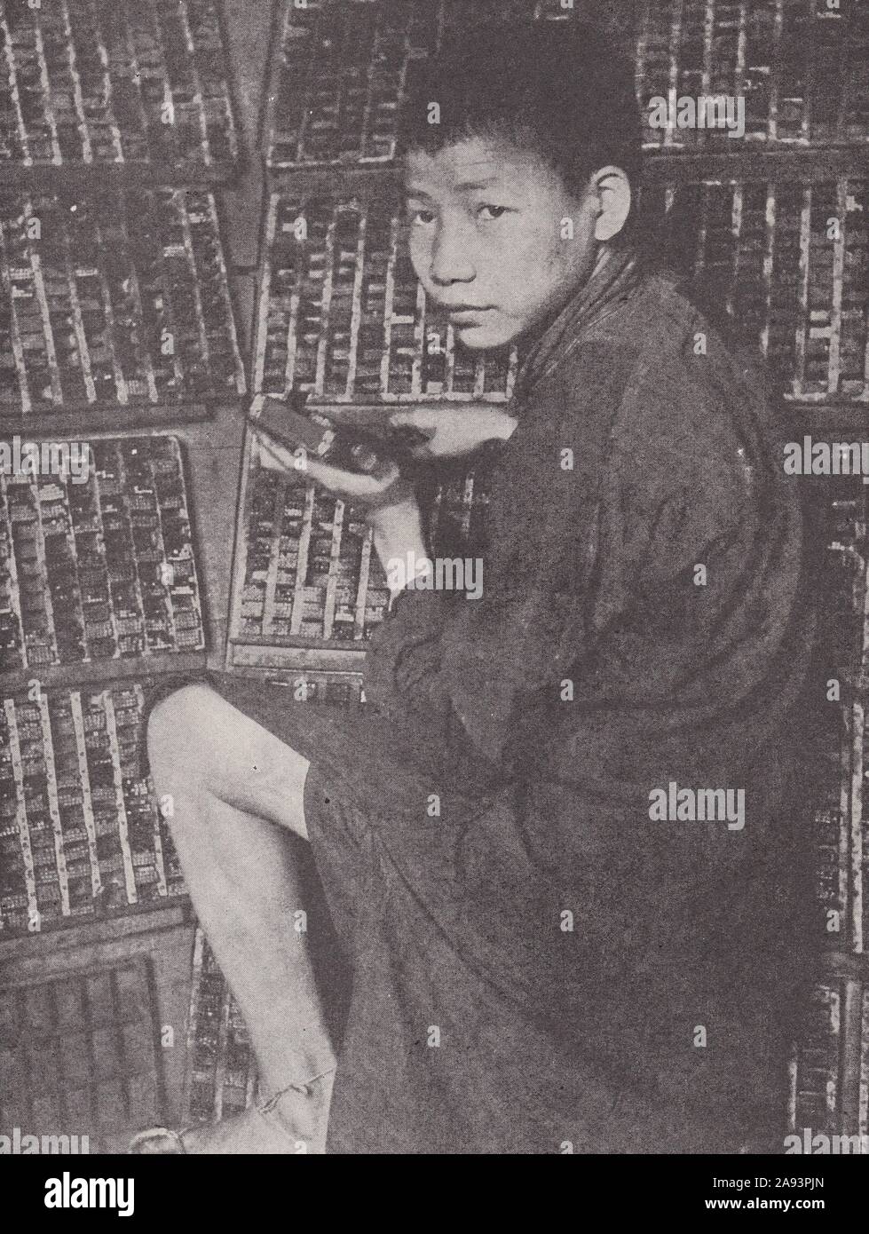 Chinese boy printer setting up type 1930s. Stock Photo