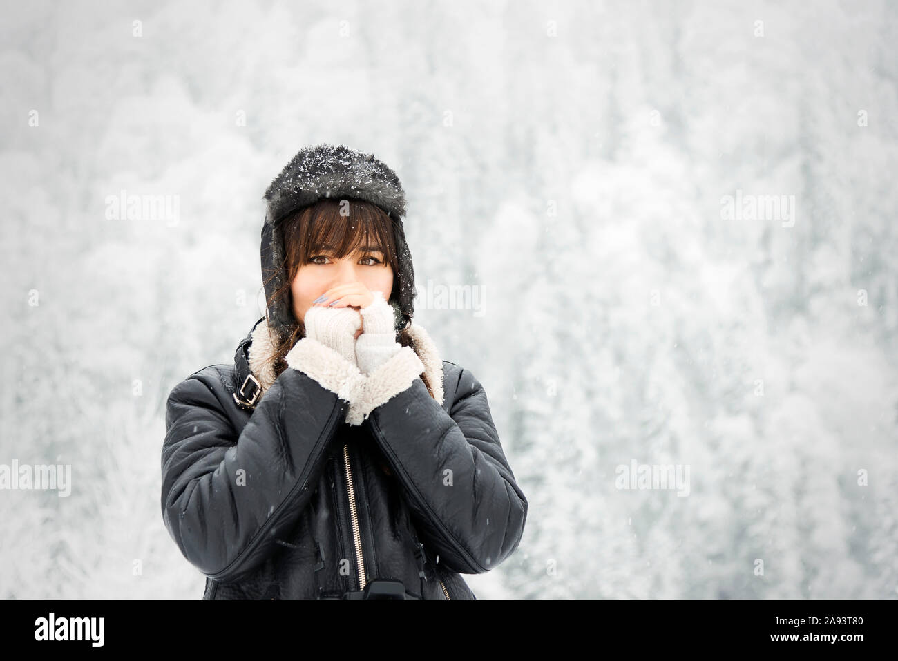 Portrait of a caucasian white woman under blizzard with hat, coat and bangs. Looking at camera. Stock Photo