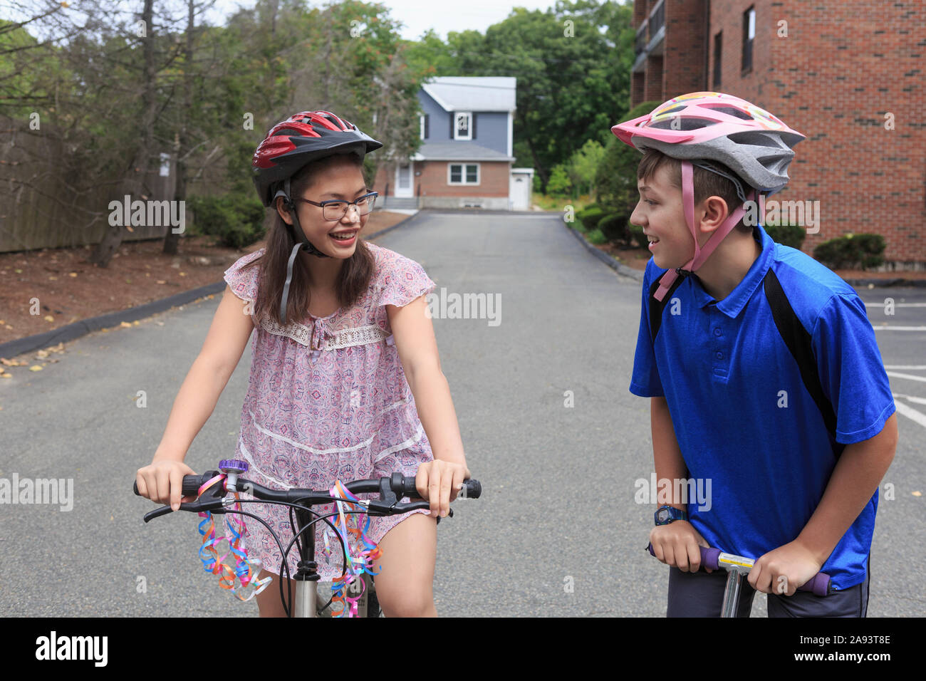 Teens girl who has Learning Disability riding bicycle with her brother Stock Photo