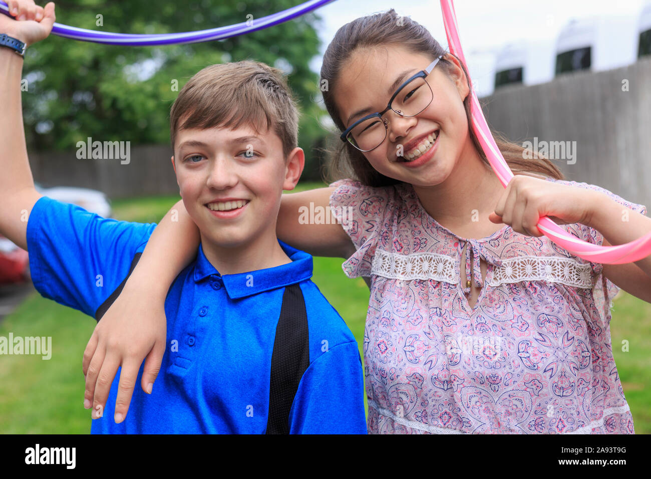 Teens girl who has Learning Disability playing hula hoops with her brother Stock Photo