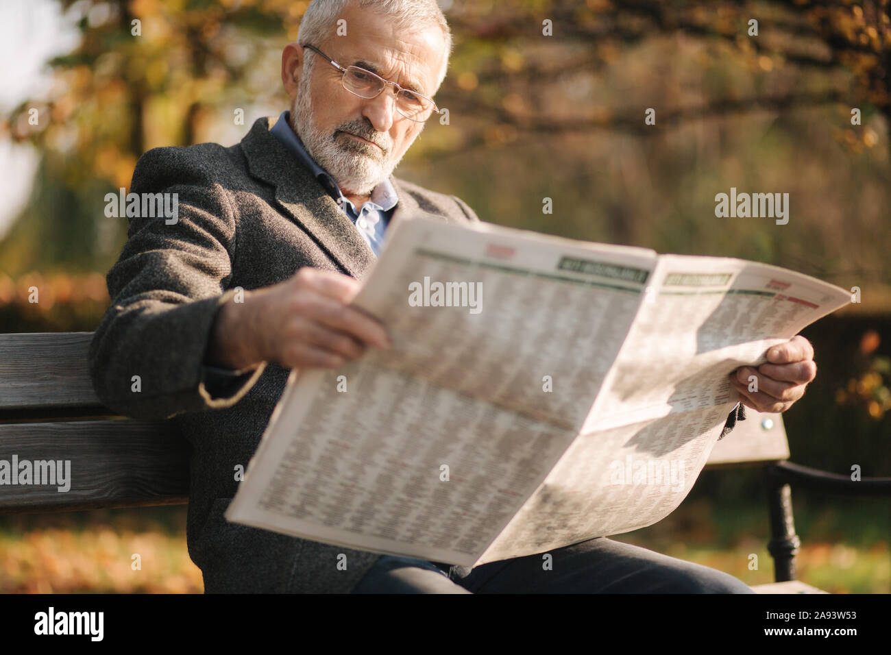 Is reading a newspaper. человек на диване с газетой. Is reading a newspaper. человек с газетой. газетные фотографии.