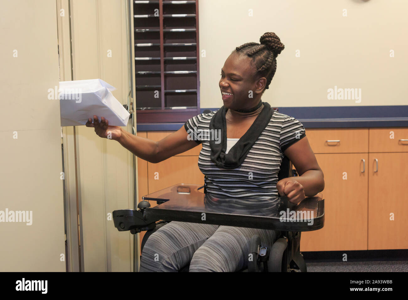 Teen with Cerebral Palsy getting copy paper Stock Photo