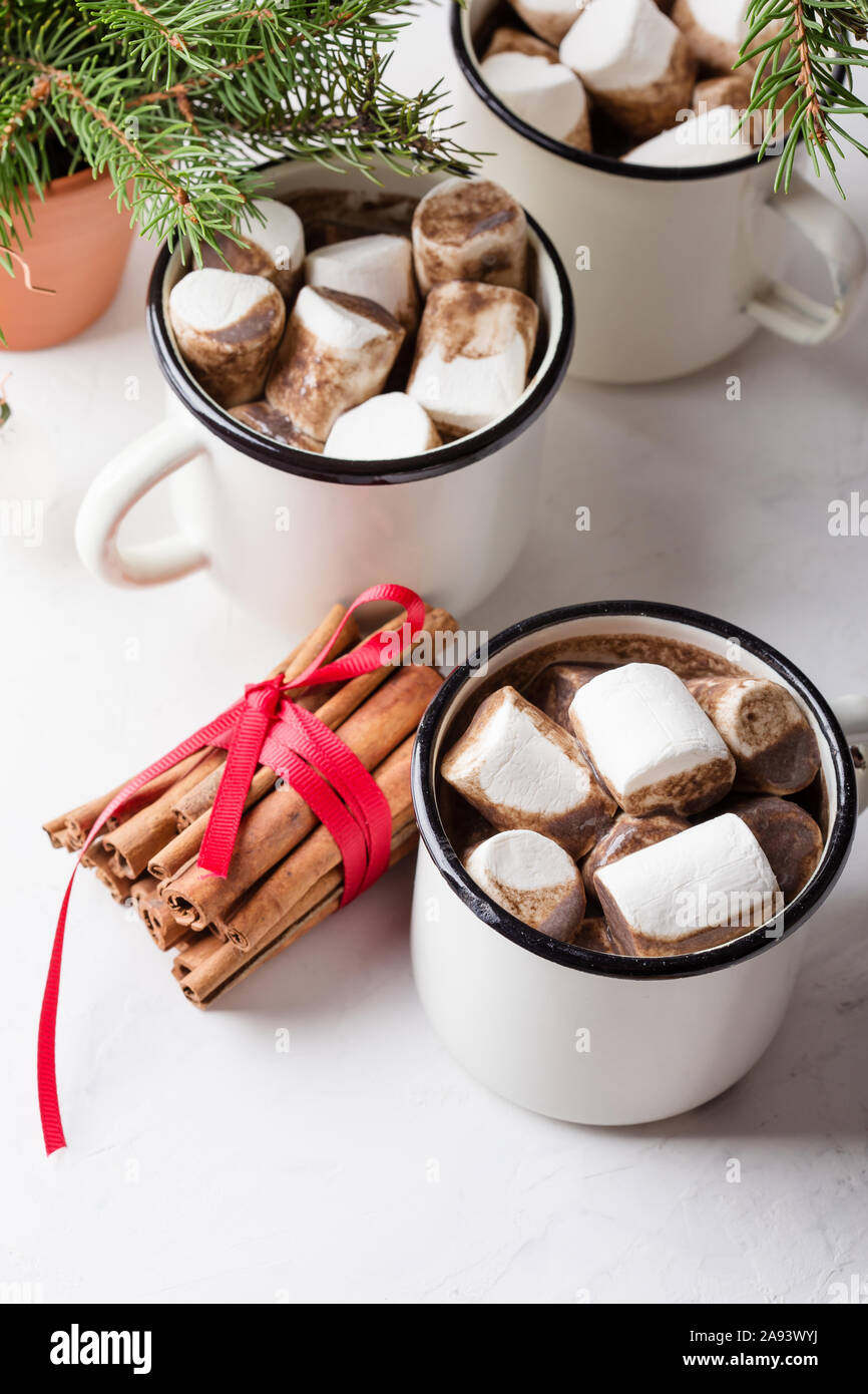 Hot chocolate, cocoa  on the festive white table, traditional autumn and winter hot drink with marshmallow in white mugs, close up Stock Photo