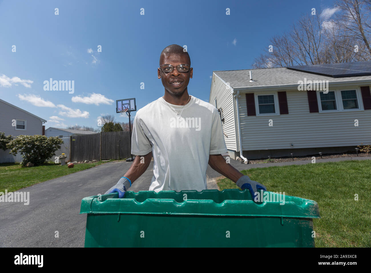 Man with Williams Syndrome taking out the trash Stock Photo