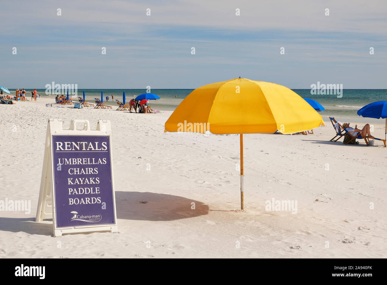 Yellow beach umbrella and sign for rental beach chairs, umbrellas, kayaks and paddle boards in Seaside Florida, USA. Stock Photo