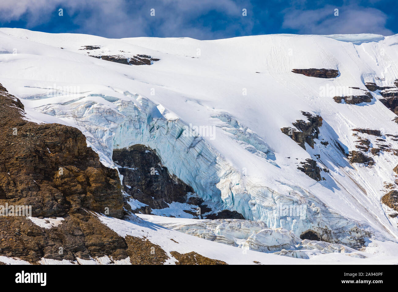 Glacier ice spills over cliffs in the Eastern Alaska Range; Alaska, United States of America Stock Photo