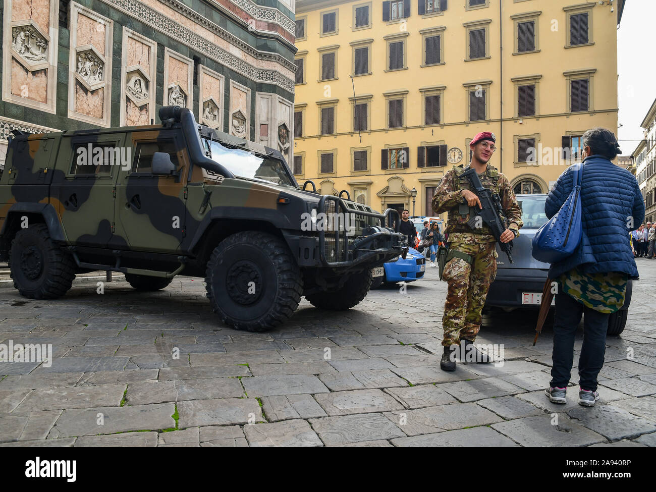 Iveco LMV military car in front of the Cathedral of Florence (Santa Maria del Fiore) with an armed soldier chatting with a lady, Tuscany, Italy Stock Photo