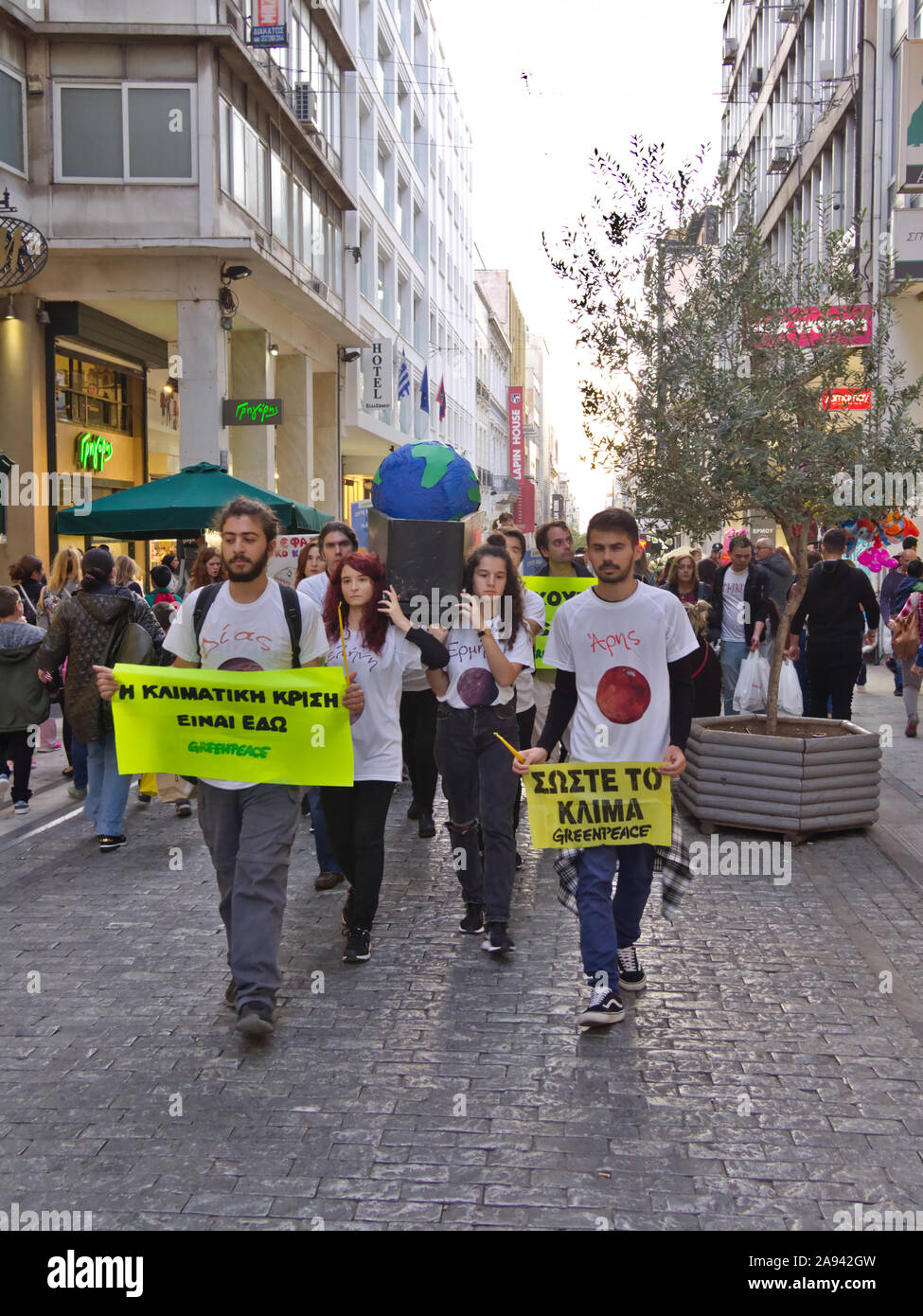 Athens / Greece - November 02 2019: Greenpeace young protesters hold banners about climate change and carry  a black coffin with a globe in Ermou stre Stock Photo