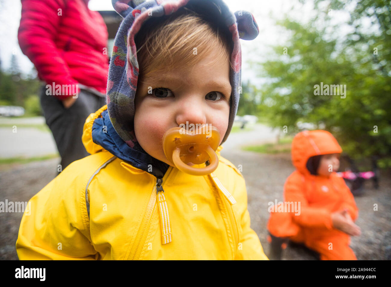 Portrait of young girl in rain suit with pacifier Stock Photo - Alamy