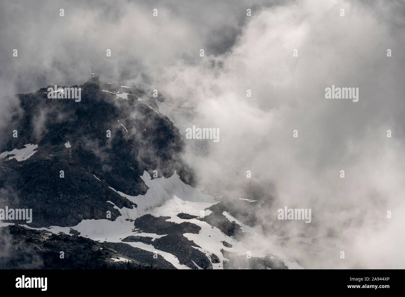 Scenic view of Whistler peak shrouded in clouds on a stormy summer day in British Columbia. Stock Photo