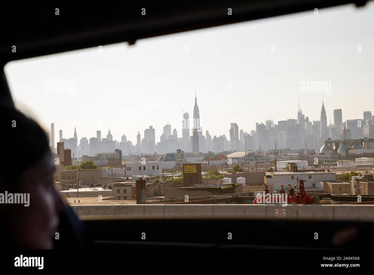 Woman admires Manhattan skyline from automobile window, Brooklyn Stock Photo